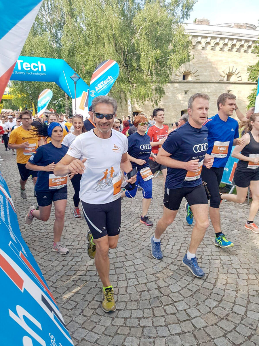 Michael Herzog im Laufwettkampf. Sommer. In der Umgebung das Audi-Team.